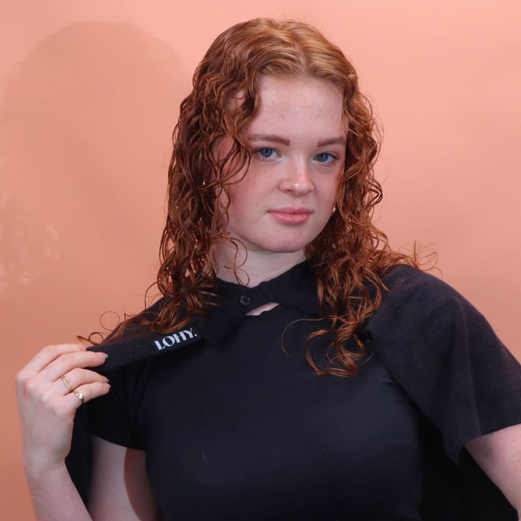 person with red wavy 2b hair wearing the cold shoulder guard