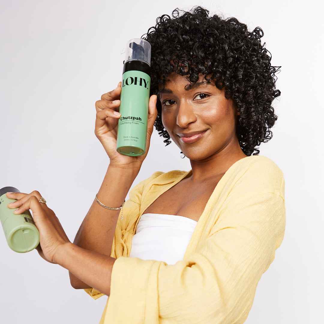 Person with 3c curls holding a bottle of curly hair volume mousse