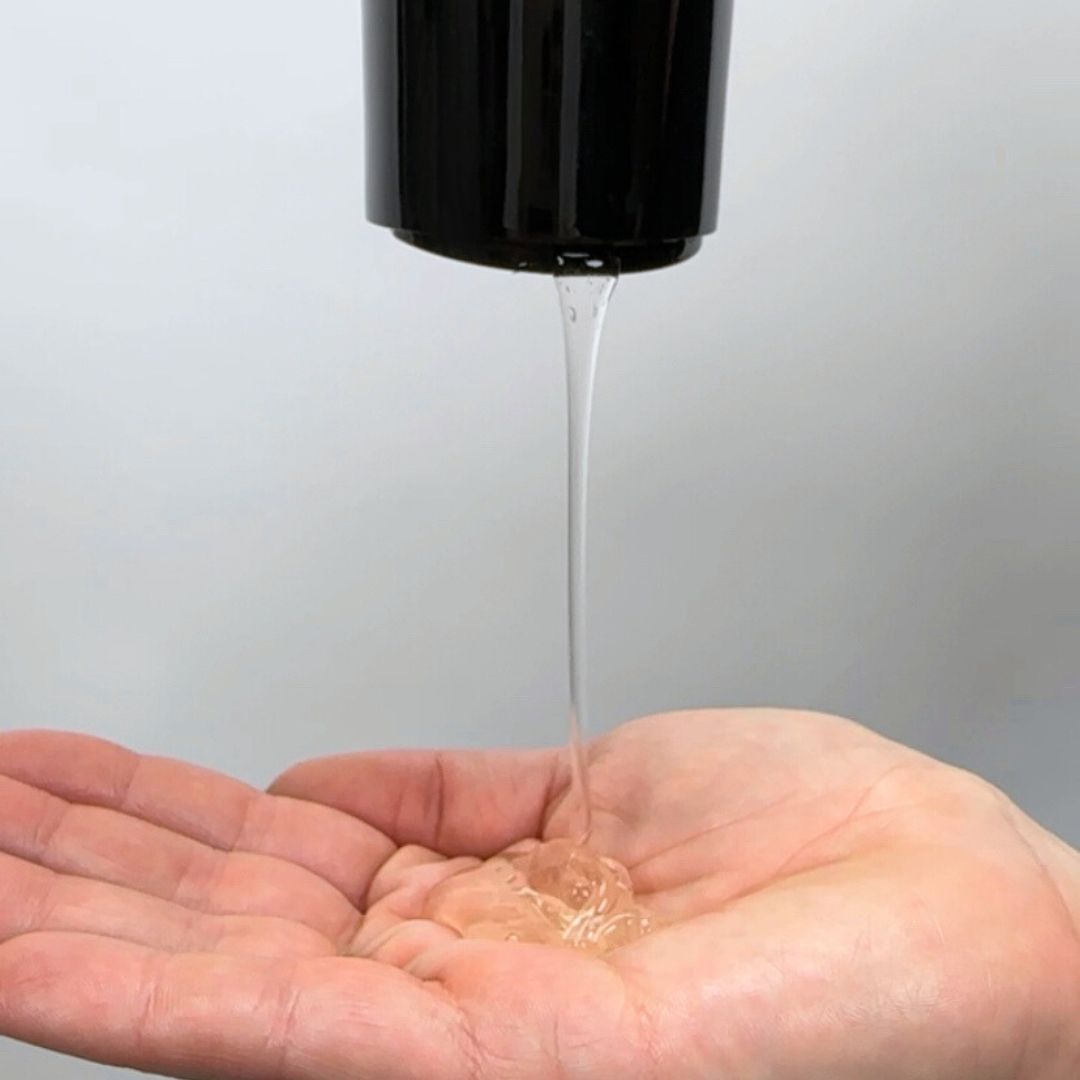 Curly hair product strong hold gel being poured into the palm of a hand