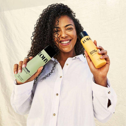 Curly girl holding the summer duo bottles