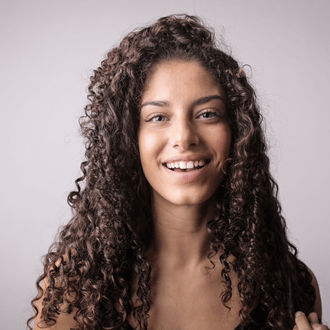 happy woman, long curly brunette hair, side part