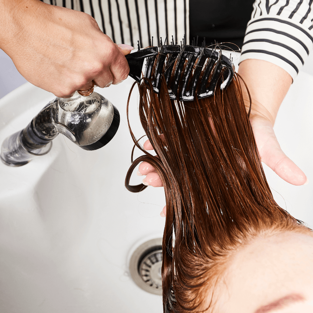 Woman brushing long red curly hair