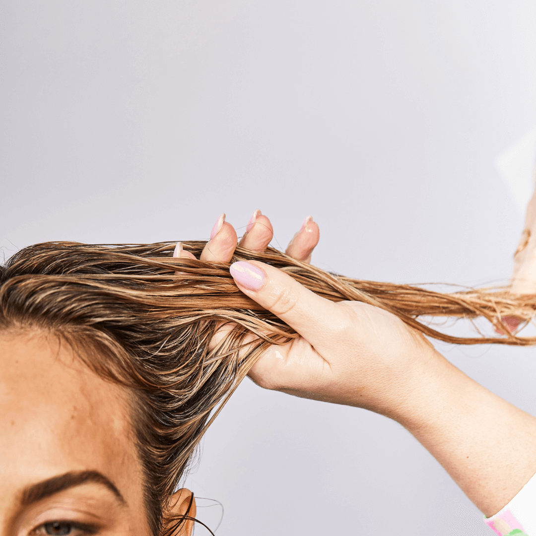 woman raking long curly blonde hair