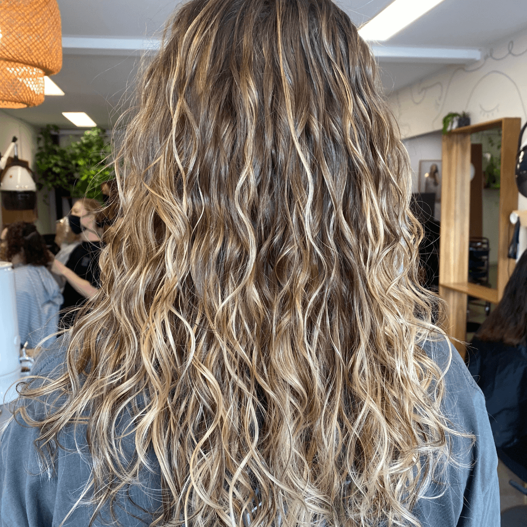 girl with curly long brunette hair with blonde accent