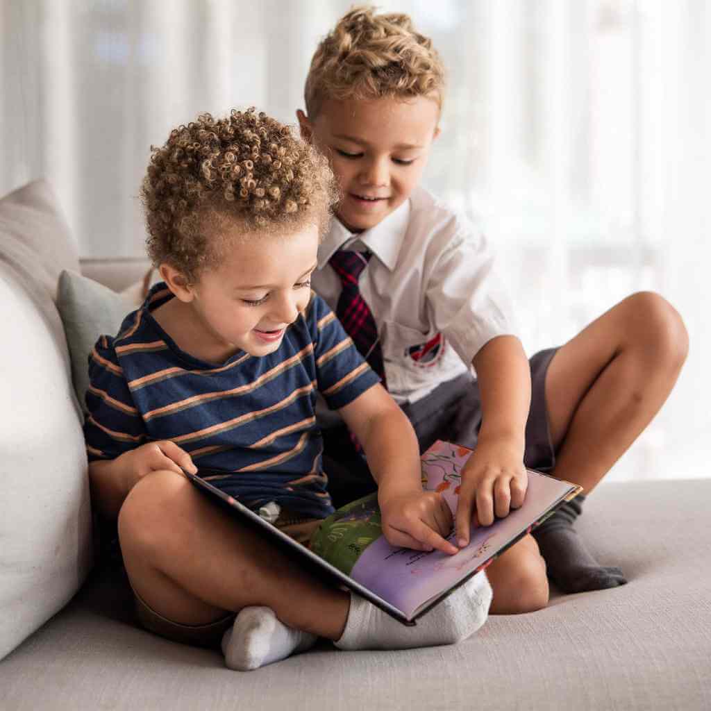 Two kids pointing while reading pearls curls book together